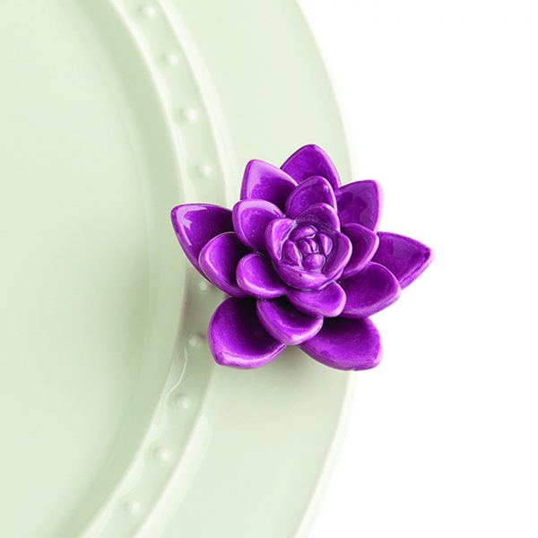 Nora Fleming Mini Get Growing – our vibrant purple succulent brings a touch of nature to your home! Perfect for an everyday addition to your favorite base piece. 