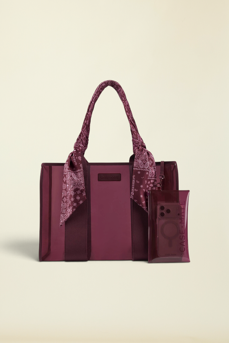 A burgundy tote bag with matching translucent phone pouch and a paisley scarf tied to the handles, shown on a plain white background.