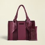 A burgundy tote bag with matching translucent phone pouch and a paisley scarf tied to the handles, shown on a plain white background.