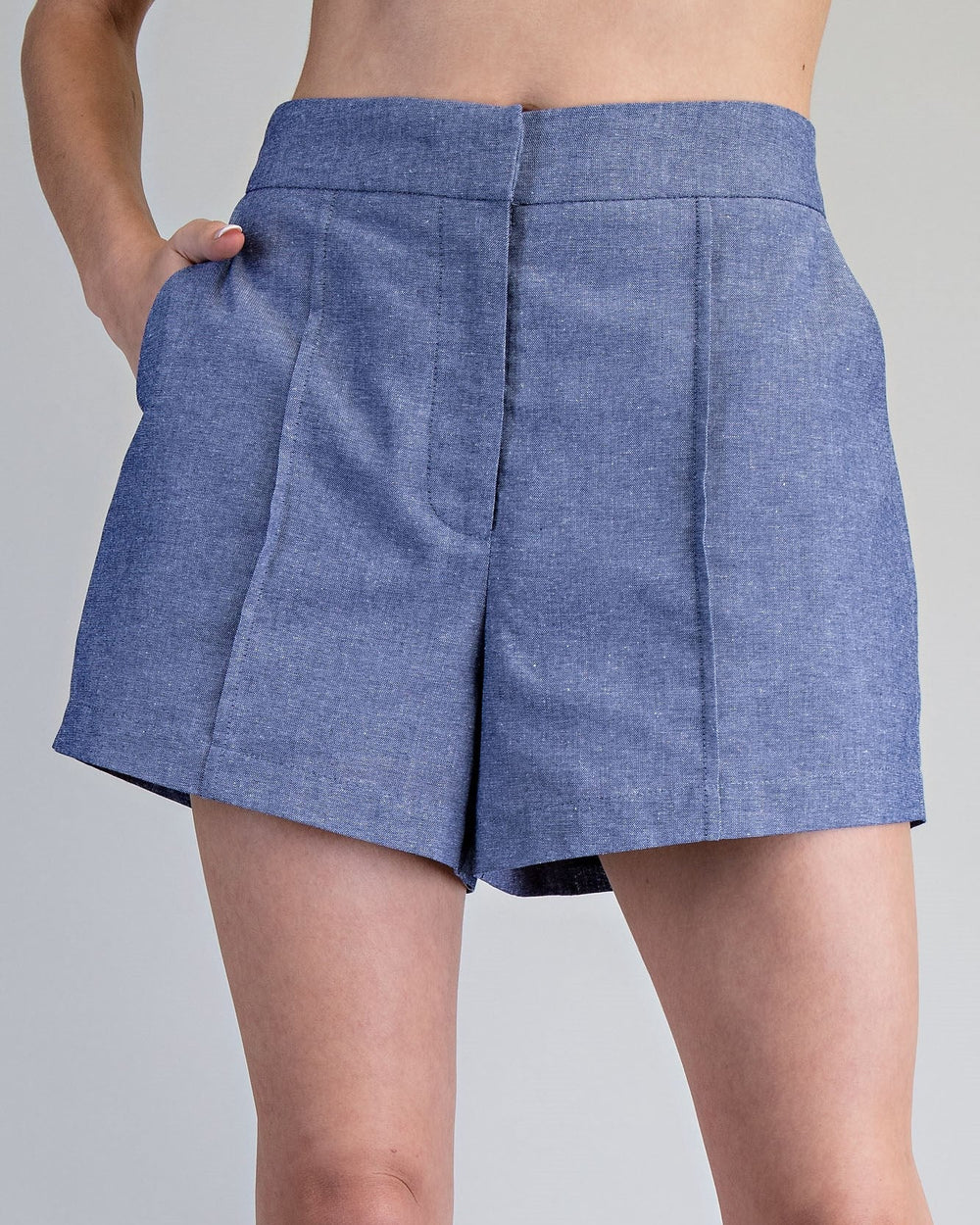 Blue denim skirt worn by a person on a gray background