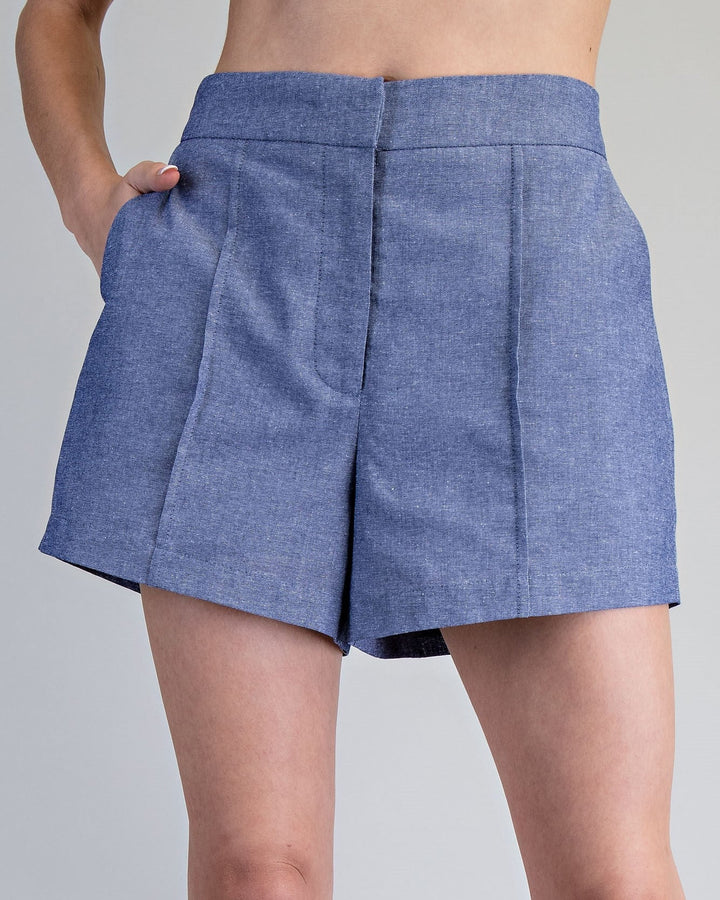 Blue denim skirt worn by a person on a gray background