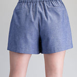 Blue shorts worn by a person on a gray background