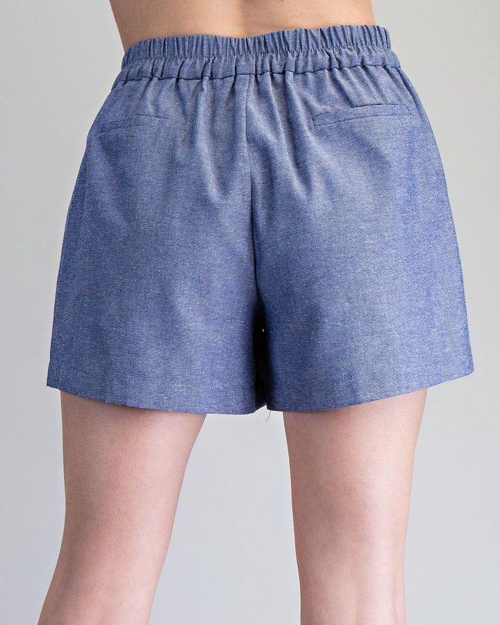 Blue shorts worn by a person on a gray background