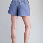 Person wearing blue shorts on a gray background