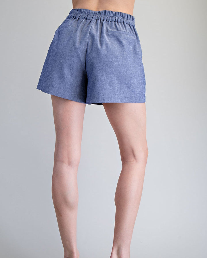 Person wearing blue shorts on a gray background
