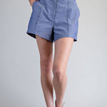 Person wearing blue shorts on a plain background
