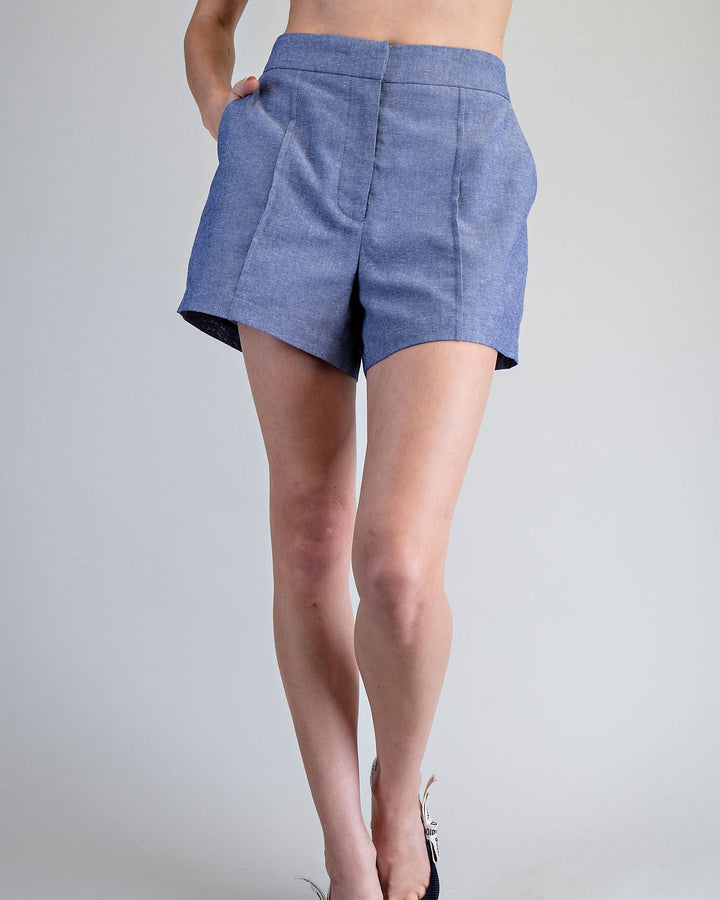 Person wearing blue shorts on a plain background