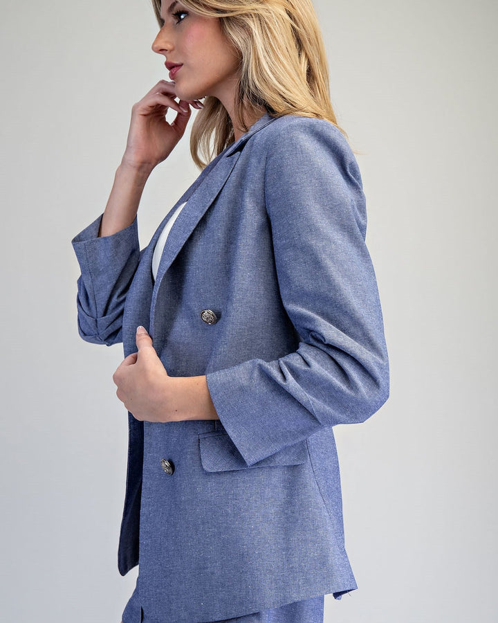 Woman wearing a blue suit with a plain background