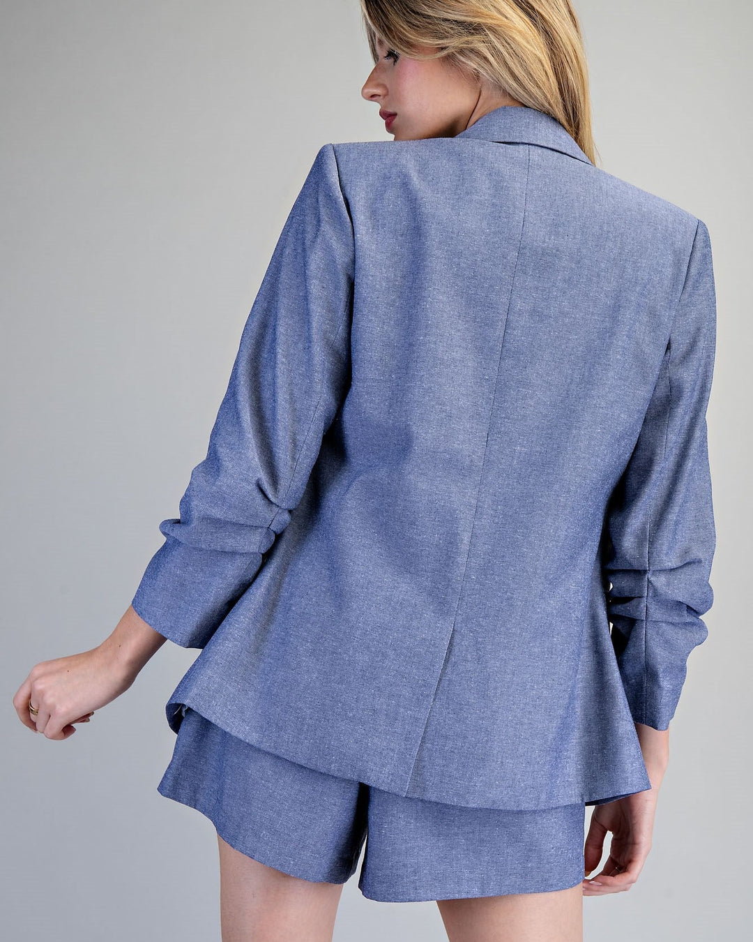 Person wearing a blue suit with shorts on a gray background