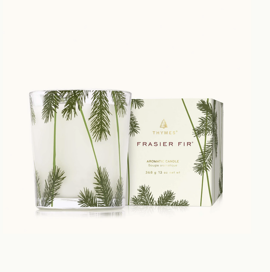 Frasier Fir candle with packaging featuring pine tree design on a white background