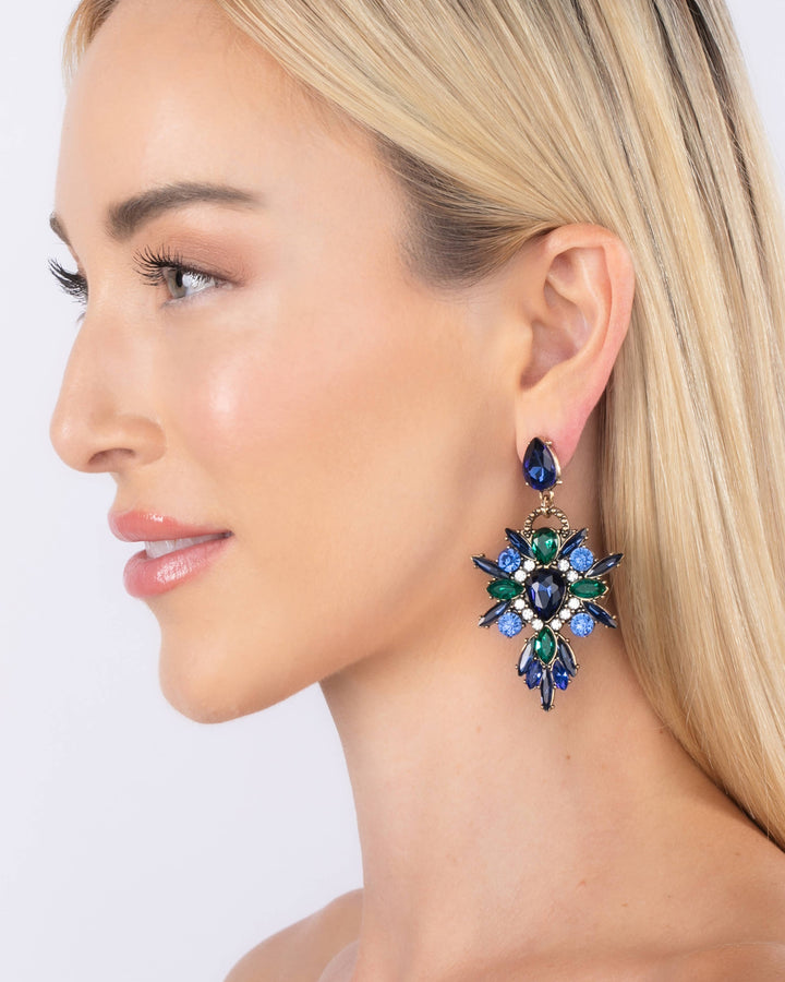 Close-up of a woman wearing a sparkling earring against a white background
