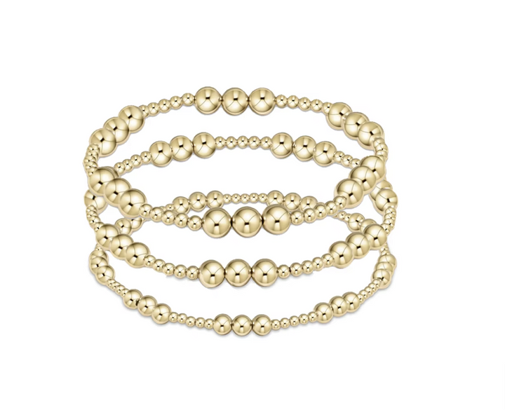 Set of gold beaded bracelets on a white background
