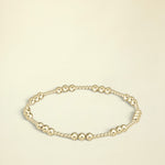 Gold beaded bracelet on a white background