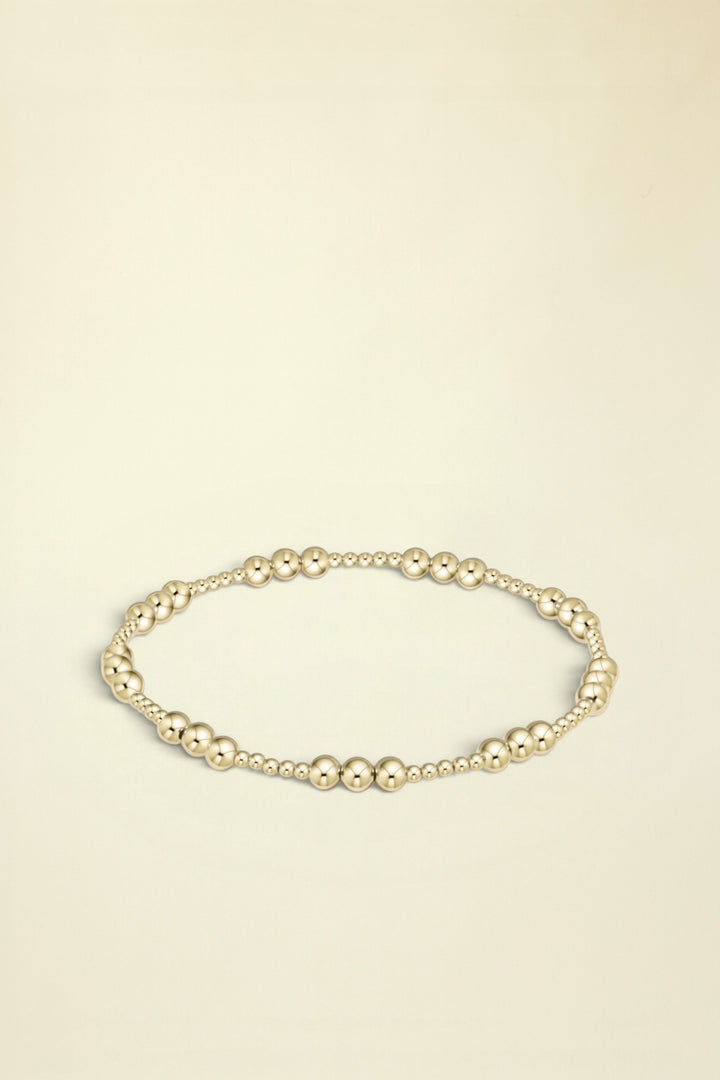 Gold beaded bracelet on a white background