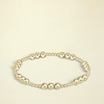 Gold beaded bracelet on a white background