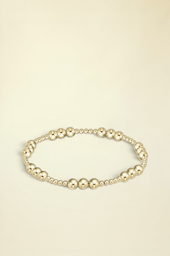 Gold beaded bracelet on a white background