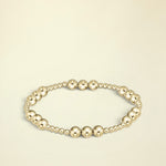Gold beaded bracelet on a white background
