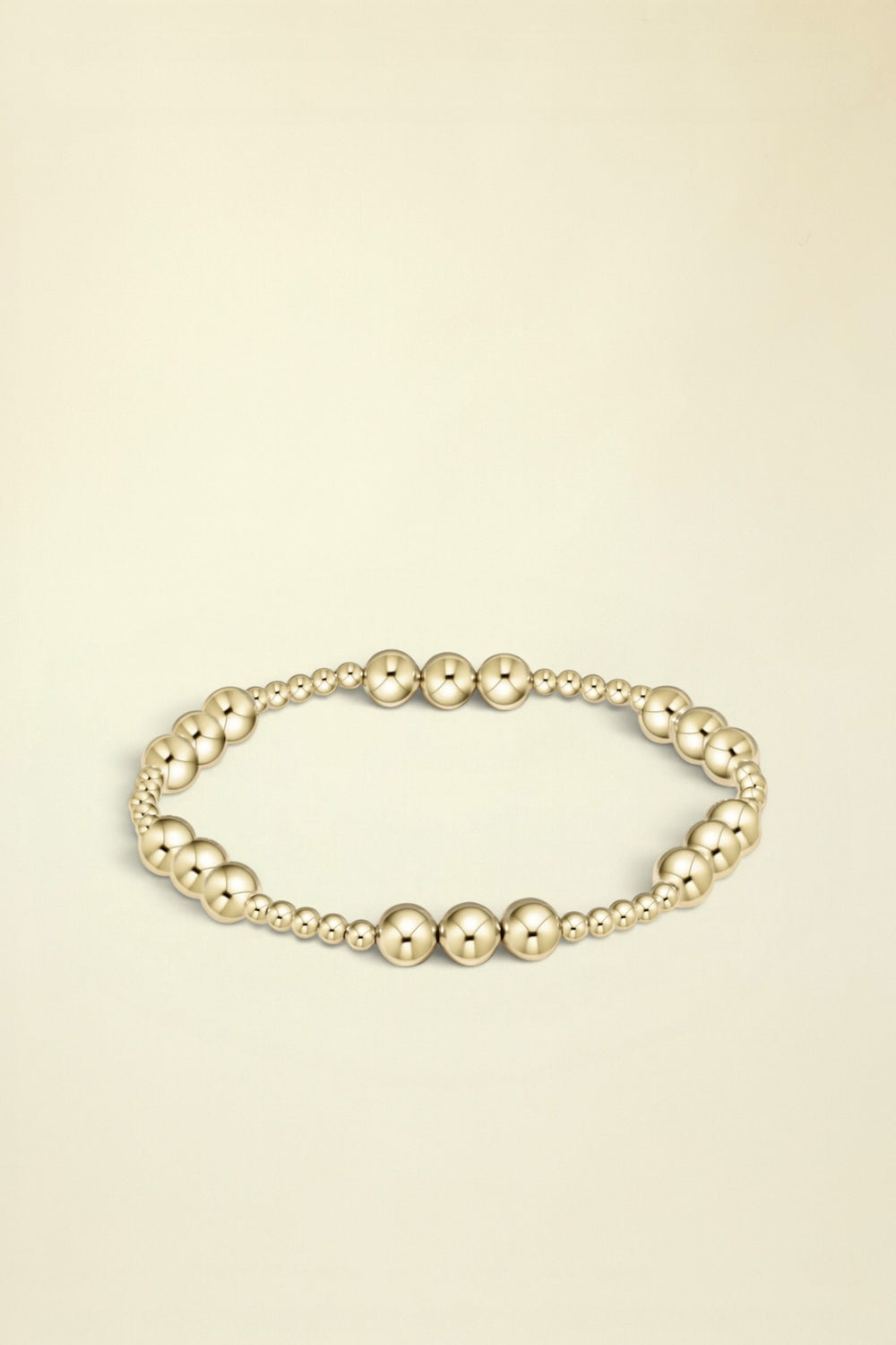 Gold beaded bracelet on a white background