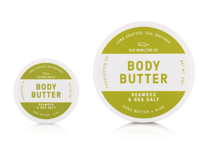 Two containers of body butter with green and white labels on a white background