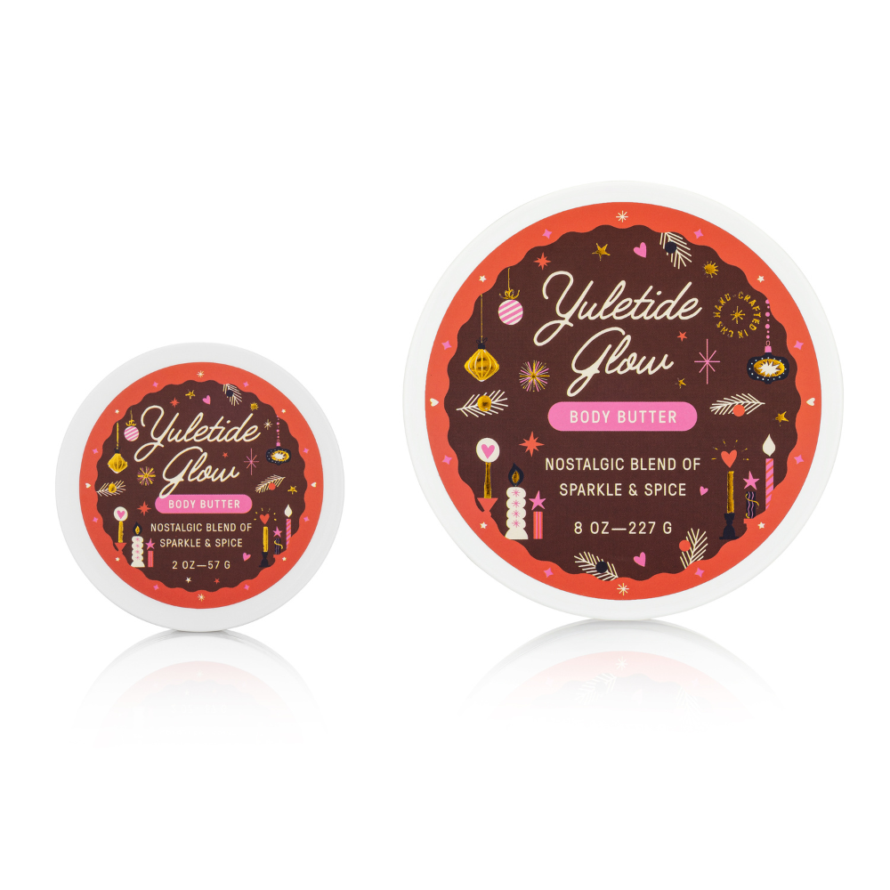 Two containers of 'Yuletide Glow' body butter on a white background