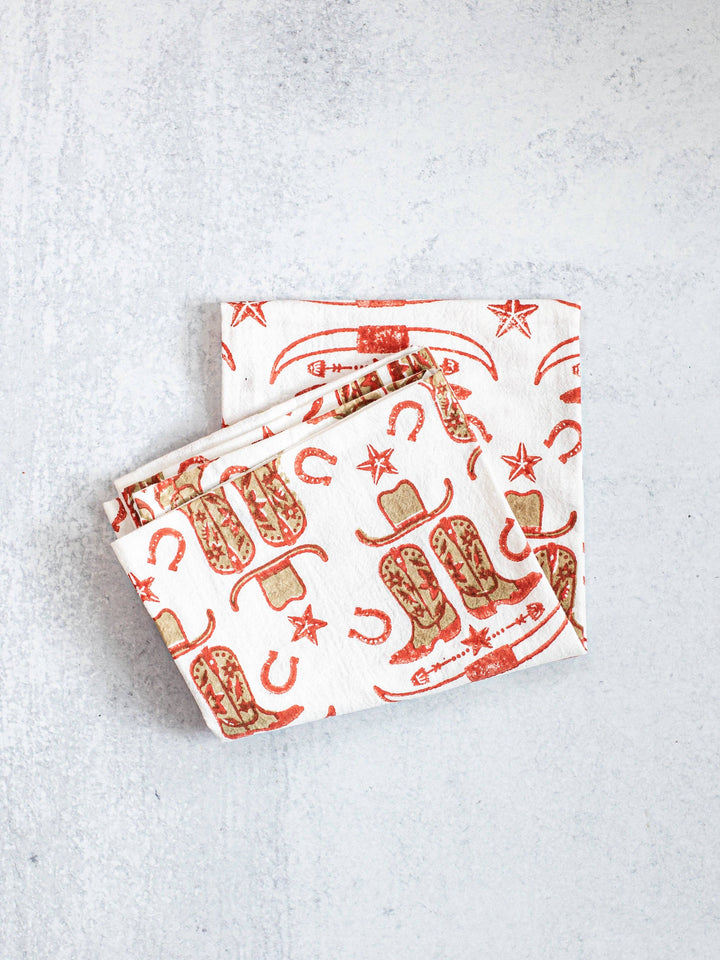 Two patterned napkins with cowboy boot design on a light gray background