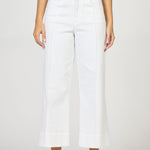 Person wearing white wide-leg jeans on a plain background