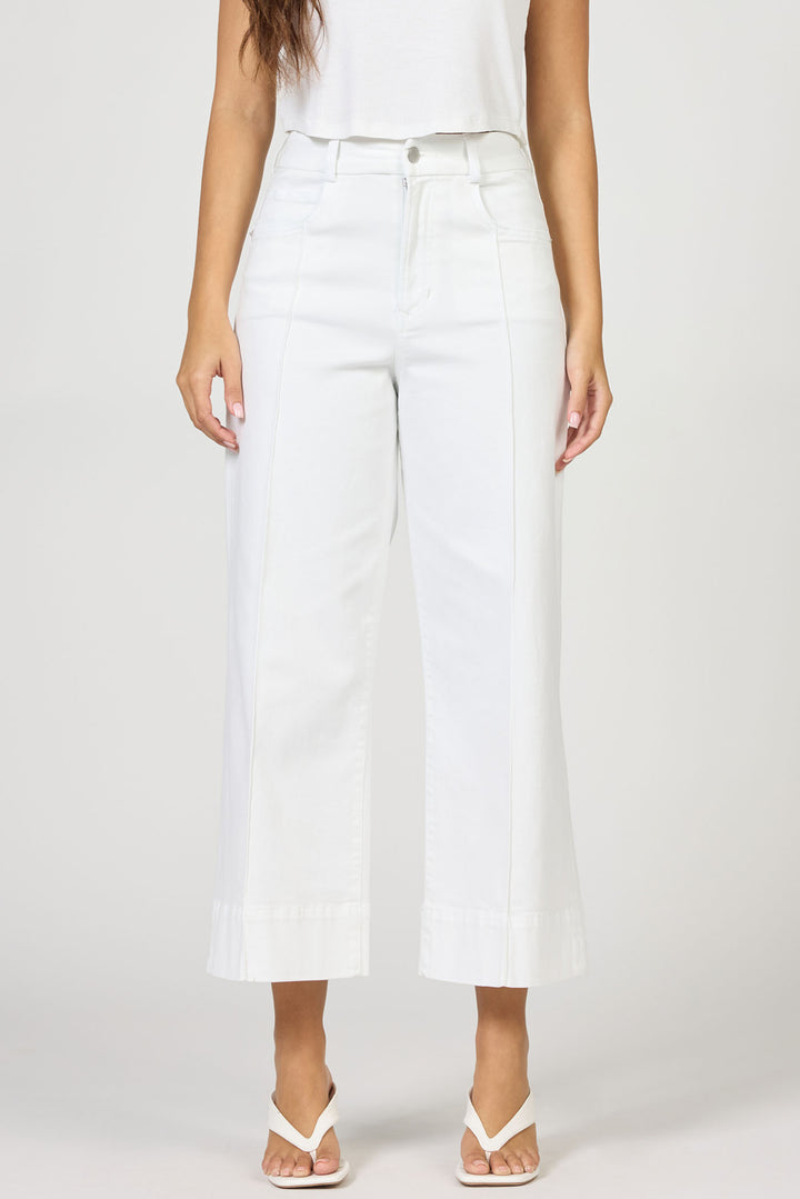 Person wearing white wide-leg jeans on a plain background