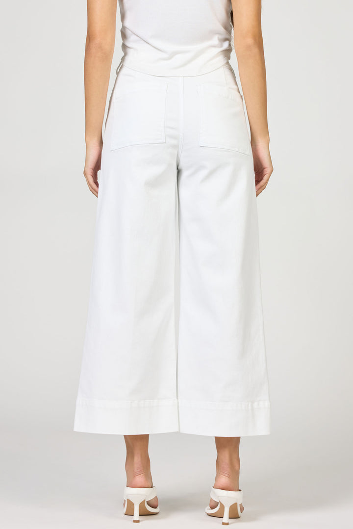 Person wearing white wide-leg pants on a plain background