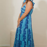 Woman wearing a blue floral dress against a plain background