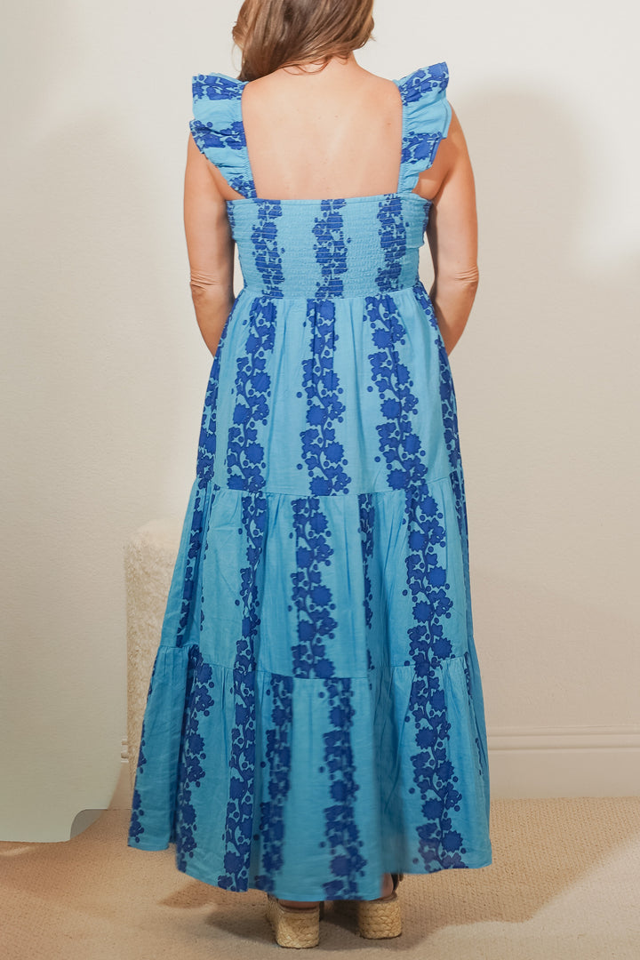 back view of woman wearing a blue print maxi dress 
