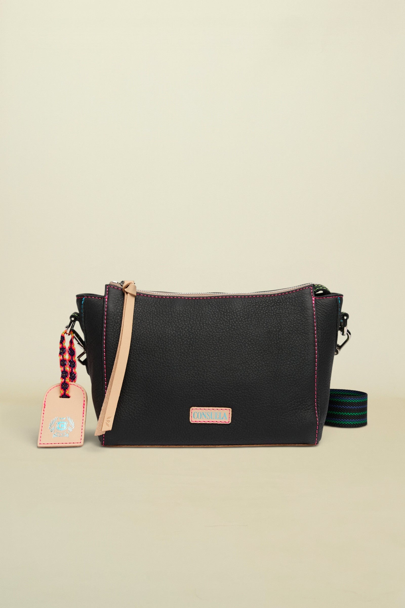Black leather crossbody bag with a strap and tag on a white background