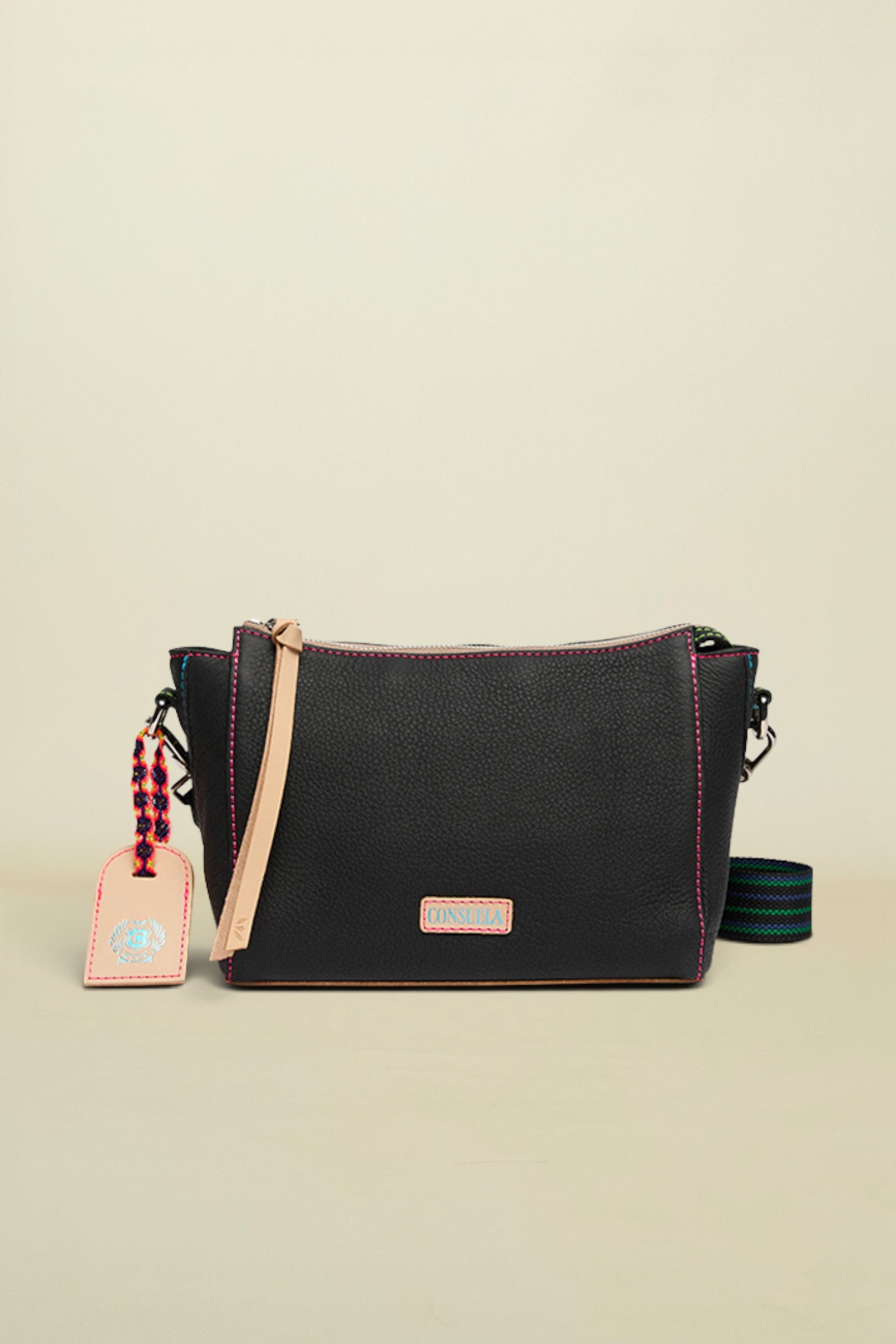 Black handbag with a strap and tag on a white background