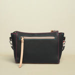 Black leather handbag with pink stitching on a white background