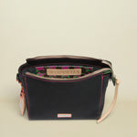 Black handbag with floral interior lining and visible Consuela branding on a white background