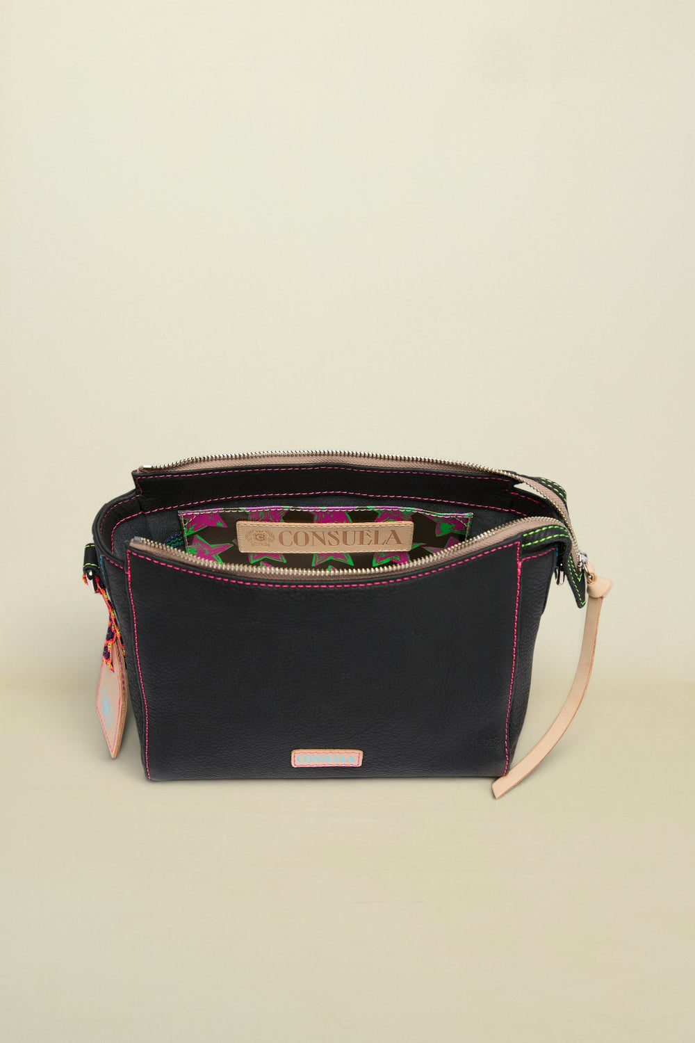 Black handbag with floral interior lining and visible Consuela branding on a white background