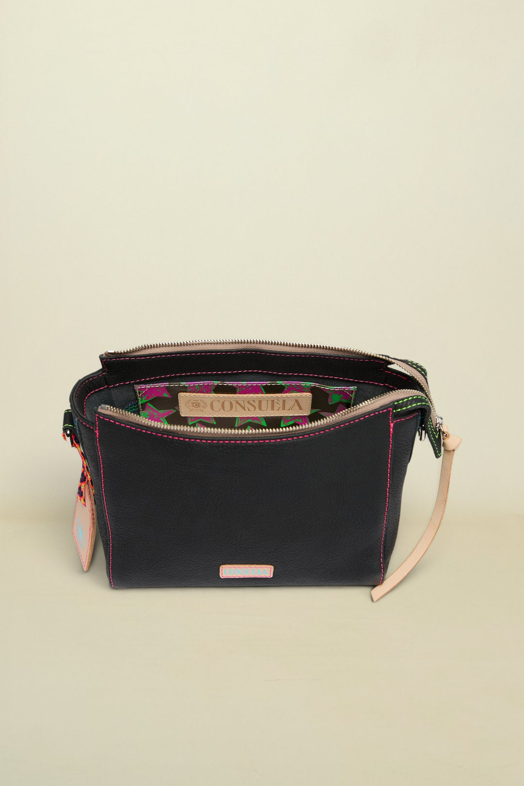 Black handbag with floral interior lining and visible Consuela branding on a white background