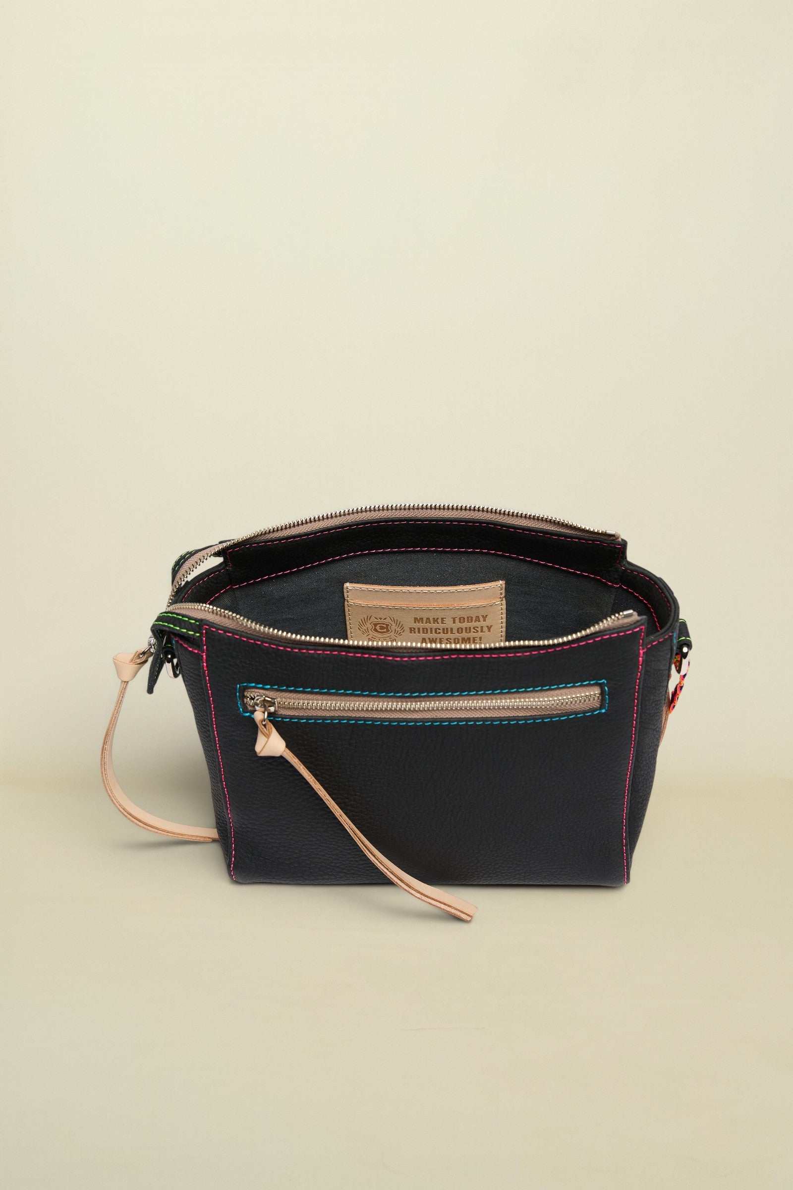 Black leather handbag with visible stitching and a strap on a white background