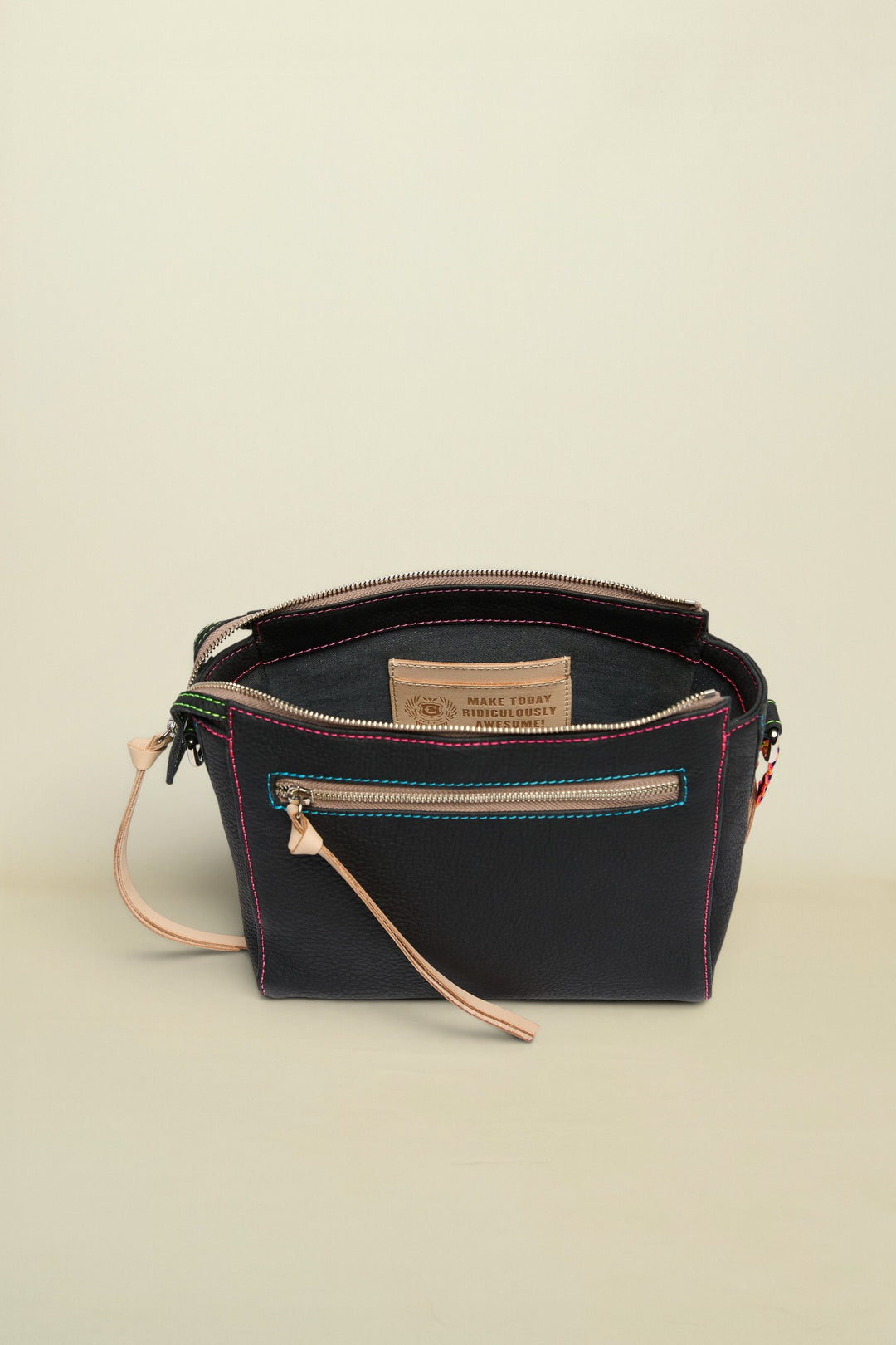 Black leather handbag with visible stitching and a strap on a white background