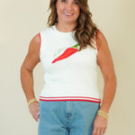 A woman modeling a white sleeveless knit top with a red and green chili pepper graphic on the chest, paired with light blue denim shorts, against a plain beige background.