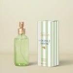 Green perfume bottle with gold cap and matching box on a white background