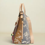 A structured handbag with a split design, featuring a brown and white marbled pattern on one side and a dusty blue and white marbled pattern on the other, with light beige leather handles, a shoulder strap, and zipper pulls, set against a solid light beige background.