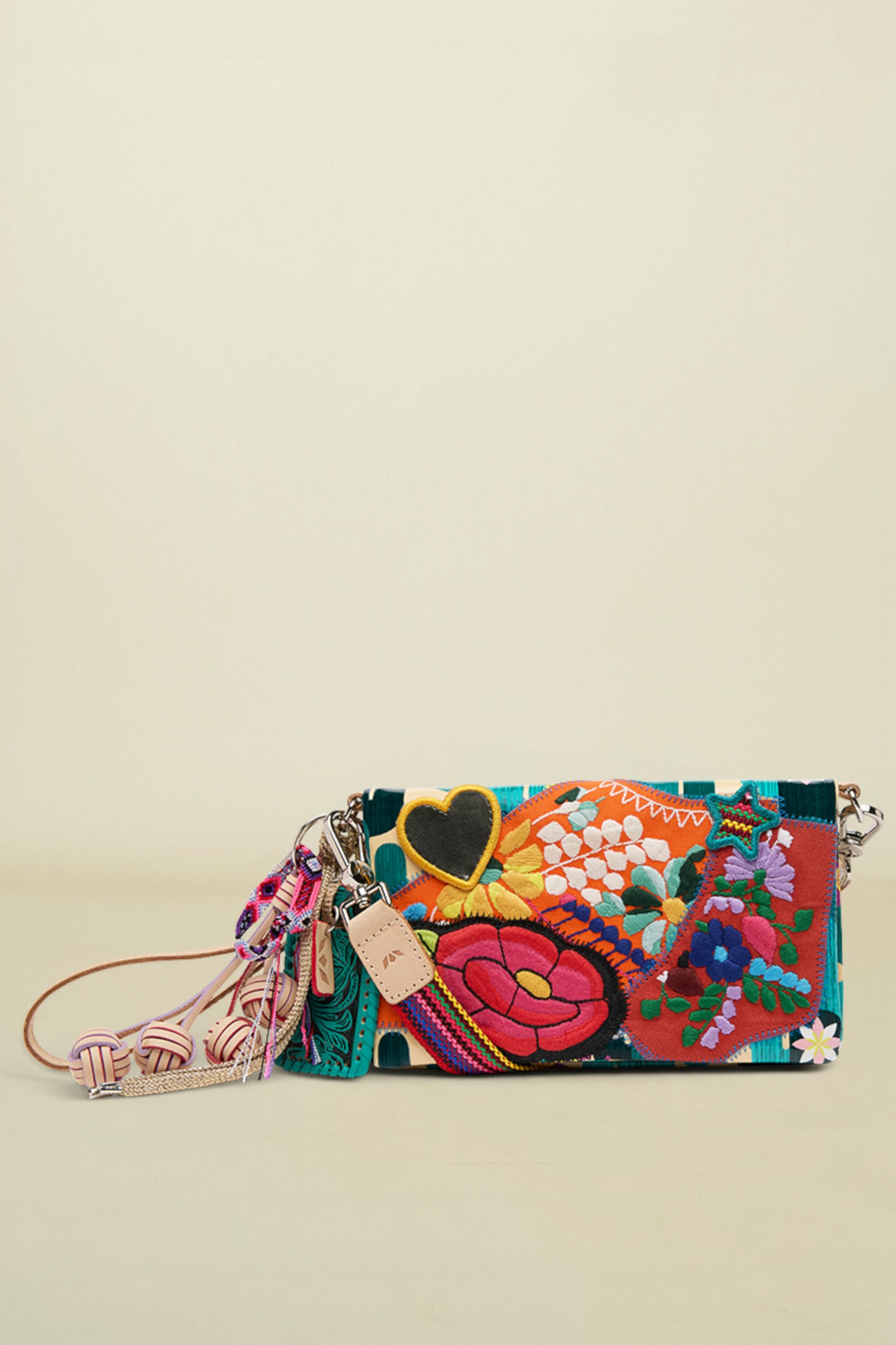 Embroidered clutch bag with floral patterns, a black heart, and decorative tassels