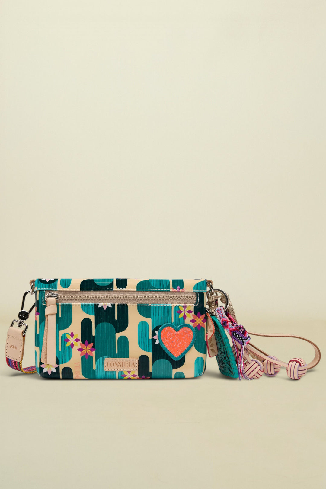 Consuela crossbody bag with a cactus print, a pink heart, and a colorful tassel
