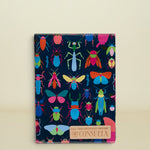 Consuela Gemma Notebook with a dark blue cover and a colorful insect pattern