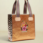 Tote bag with floral embroidery and colorful striped handles on a beige background