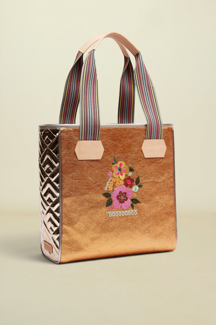 Tote bag with floral embroidery and colorful striped handles on a beige background