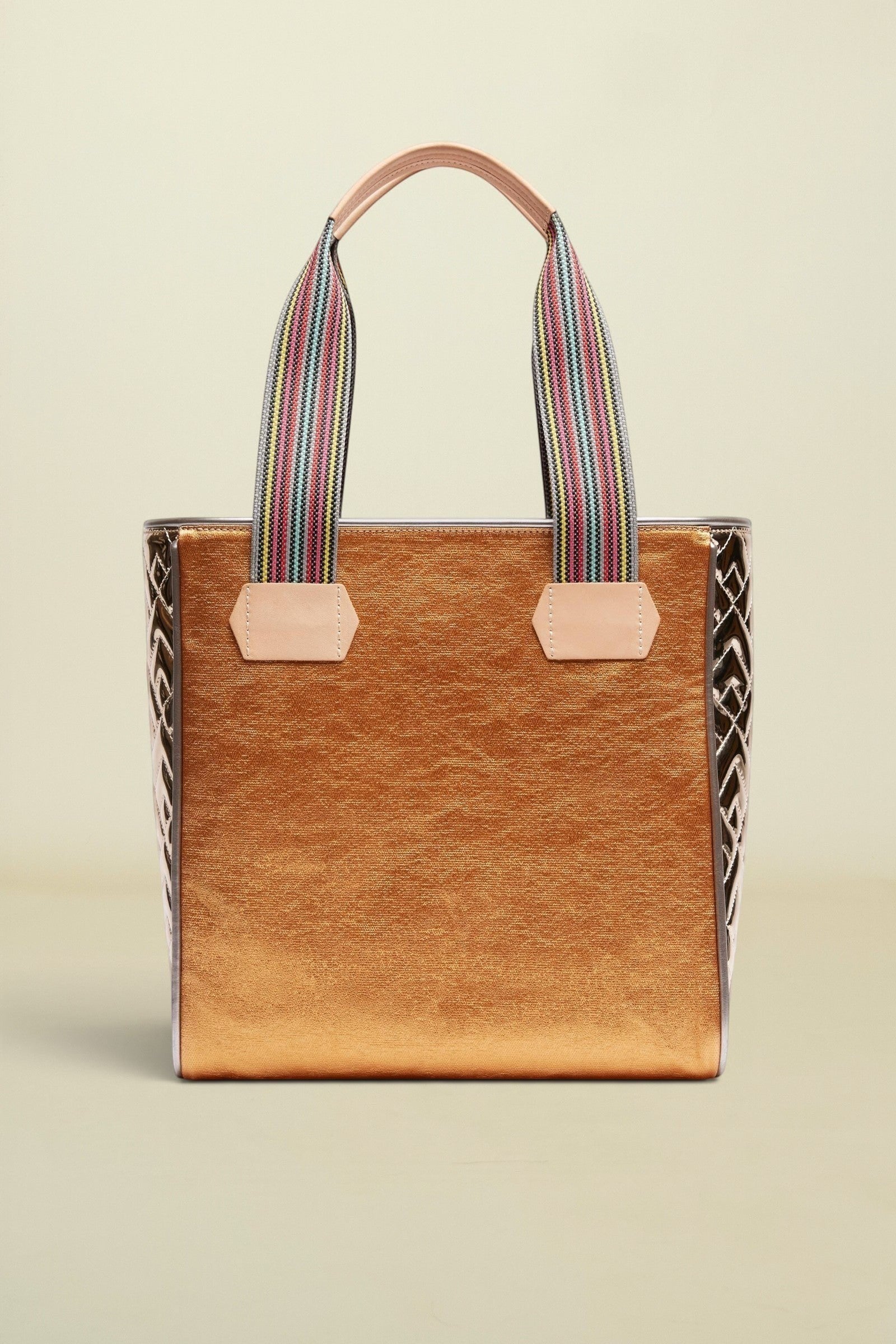 Brown tote bag with striped handles on a beige background