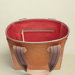 Brown tote bag with colorful handle on a beige background