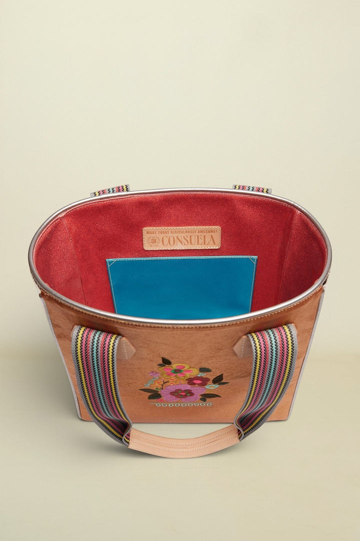 Handbag with floral embroidery and colorful handle on a beige background
