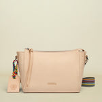 Beige handbag with a colorful strap and tag on a white background